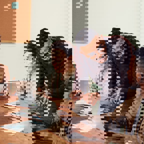 Three people on laptops and talking