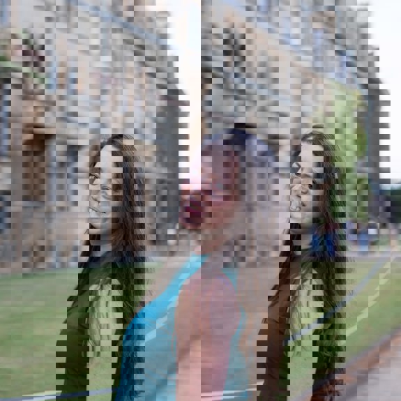 Woman smiling in front of university